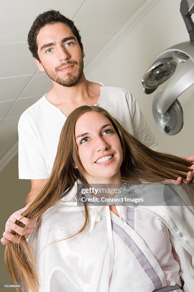 Hairdresser and girl with long hair