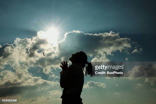 silhouette of woman praying at sunset - spirituality foto e immagini stock
