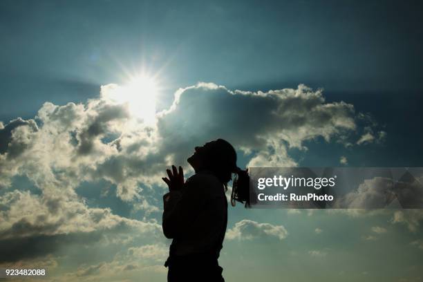 silhouette of woman praying at sunset - ポジティブな感情 ストックフォトと画像