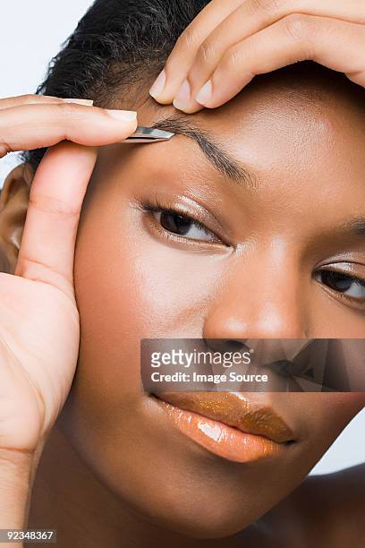 young woman plucking eyebrows - ピンセット ストックフォトと画像