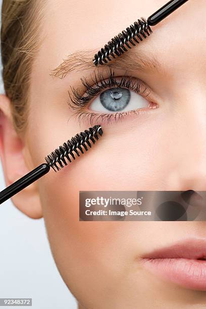 woman with two mascara brushes - applying mascara stock pictures, royalty-free photos & images