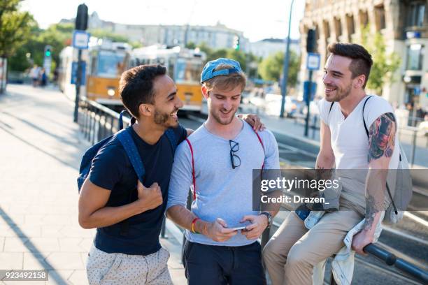 drei homosexuelle männer gehen zum festival im sommer - nur junge männer stock-fotos und bilder