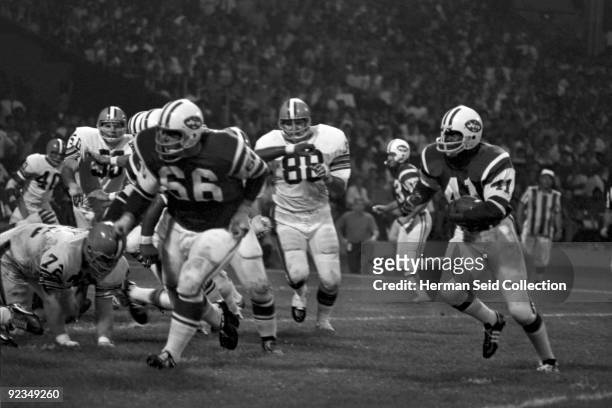 Runningback Matt Snell of the New York Jets runs with the ball as guard Randy Rasmussen leads the blocking during a game on September 21, 1970...