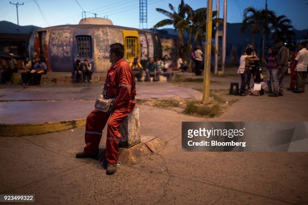Petroleos de Venezuela SA employee waits at a bus stop n Puerto La Cruz, Anzoategui State, Venezuela, on Wednesday, Feb. 7, 2018. Hunger is hastening...