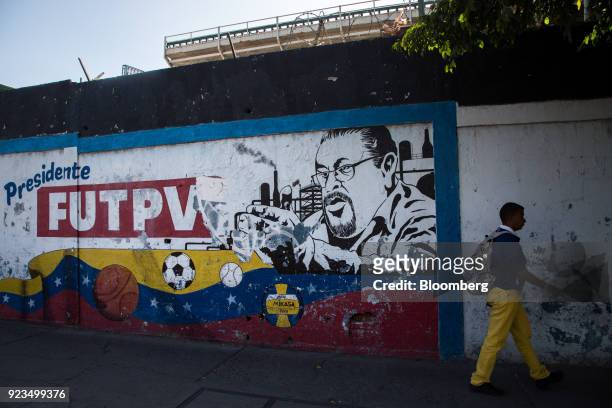 Pedestrian passes in front of a mural of Wills Rangel, president of the Federation of Oil Workers of Venezuela, on a street in Puerto La Cruz,...