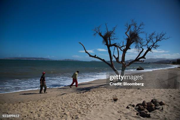 Petroleos de Venezuela SA workers walk along a beach in Puerto La Cruz, Anzoategui state, Venezuela, on Wednesday, Feb. 7, 2018. Hunger is hastening...