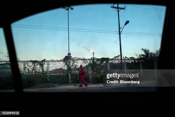 Petroleos de Venezuela SA worker passes in front of a refinery in Puerto La Cruz, Anzoategui state, Venezuela, on Wednesday, Feb. 7, 2018. Hunger is...