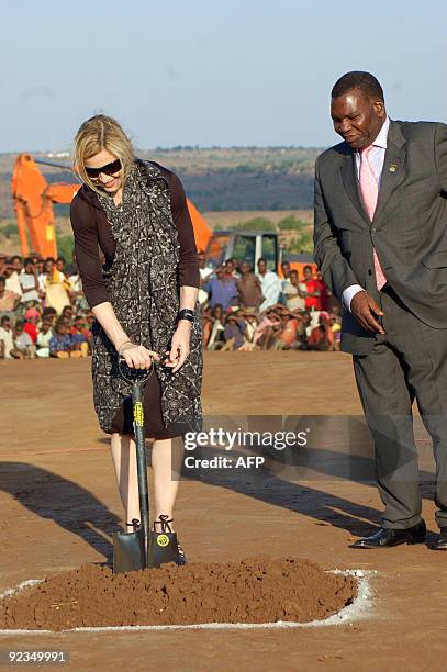 American pop queen Madonna uses a shovel next to Malawi�s Education Minister George Chiponda during a ceremony to officially launch the construction...