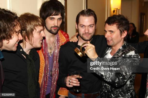 Ian Matthews, Chris Edwards, Sergio Pizzorno, Tom Meighan and Matt Bellamy pose with Muse's Best Act in the World award at the 2009 Q Awards held at...
