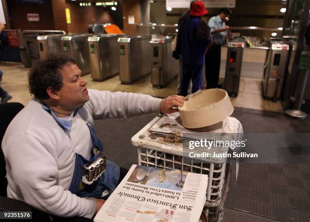Newspaper vendor Rick Gaub checks his change bowl as he waits for customers at his stand in an underground rail station October 26, 2009 in San...
