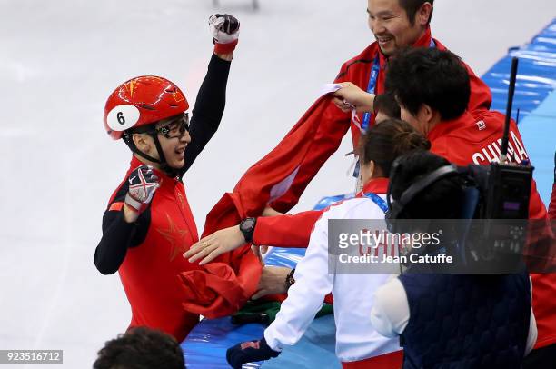 Dajing Wu of China celebrates his victory with his coaches following the Short Track Speed Skating Men's 500m Final A on day thirteen of the...