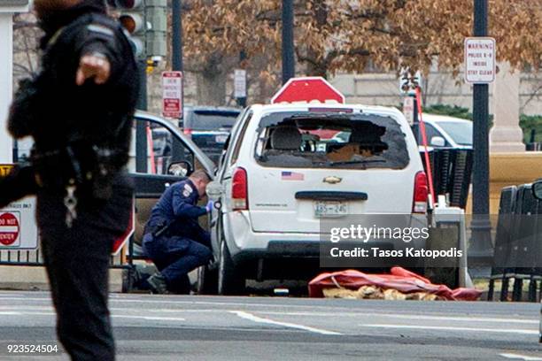 First responder inspects a vehicle that crashed into a barricade on the perimeter of the White House grounds February 23, 2018 in Washington, DC. A...