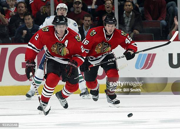 Duncan Keith and Colin Fraser of the Chicago Blackhawks chase after the puck during a game against the Vancouver Canucks on October 21, 2009 at the...