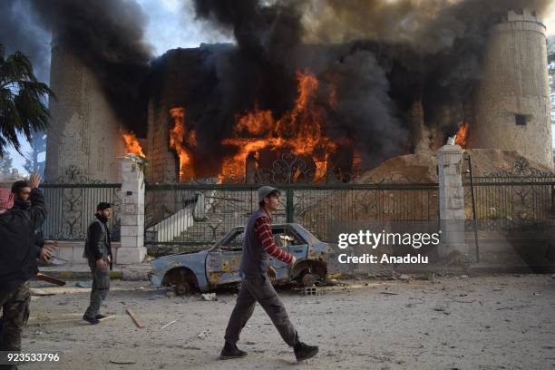 Citizens and fire fighters arrive to extinguish fire after Assad regime forces carried out an airstrike over the de-escalation zone in Douma town of...