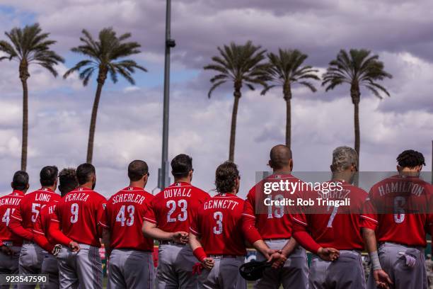 Members of the Cincinnati Reds stand for the National Anthem before a game against the Cleveland Indians during a Spring Training Game at Goodyear...