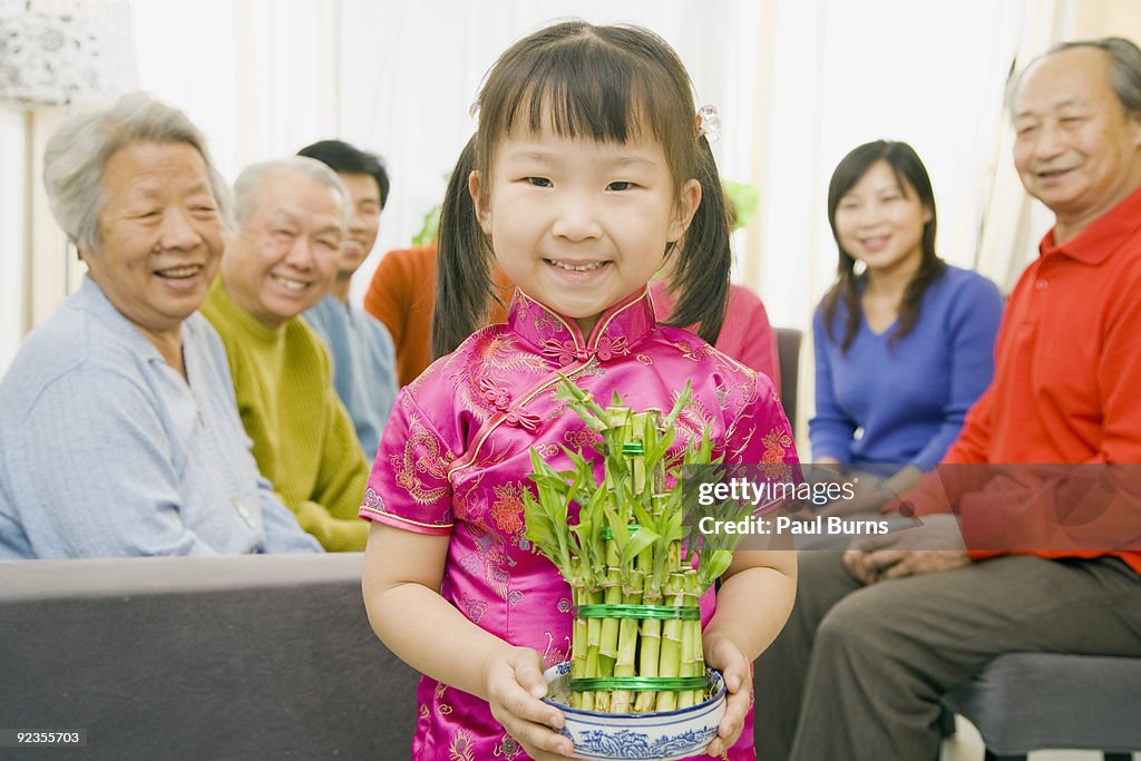 Asian girl holding a pot of lucky bamboo