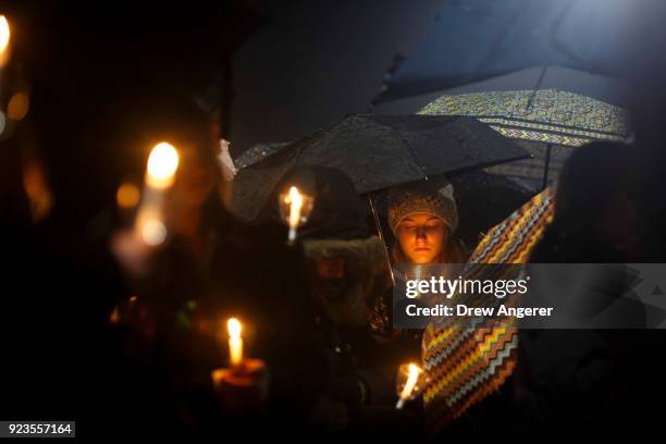 Mourners pause as names are read aloud during a community vigil at Newtown High School for the victims of last week's mass shooting at Marjory...