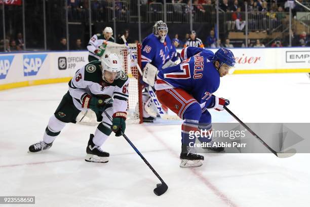 Tyler Ennis of the Minnesota Wild reaches for the puck against Tony DeAngelo of the New York Rangers in the first period during their game at Madison...