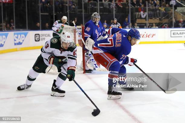 Tyler Ennis of the Minnesota Wild reaches for the puck against Tony DeAngelo of the New York Rangers in the first period during their game at Madison...