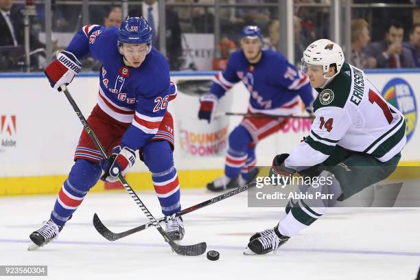 Jimmy Vesey of the New York Rangers fights for the puck against Joel Eriksson Ek of the Minnesota Wild in the second period during their game at...