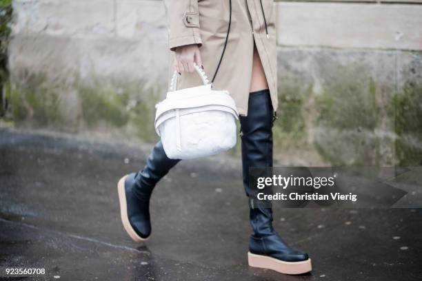 Guest wearing overknees boots, white bag seen outside Tods during Milan Fashion Week Fall/Winter 2018/19 on February 23, 2018 in Milan, Italy.