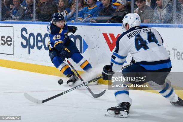 Ivan Barbashev of the St. Louis Blues and Josh Morrissey of the Winnipeg Jets battle for the puck at Scottrade Center on February 23, 2018 in St....