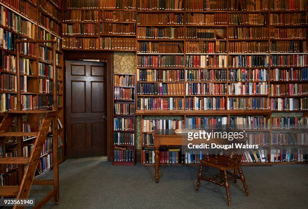 open book on table and chair in traditional library. - antique desk stock pictures, royalty-free photos & images