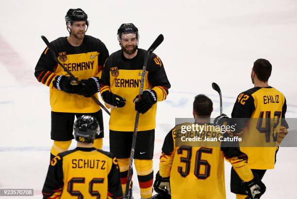 Marcus Kink and Gerrit Fauser of Germany celebrate with teammates after victory in Men's Semifinal ice hockey match between Canada and Germany on day...