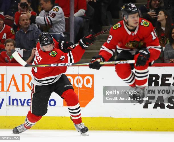 Connor Murphy of the Chicago Blackhawks gets off a shot as Alex DeBrincat leaps out of the way against the San Jose Sharks at the United Center on...