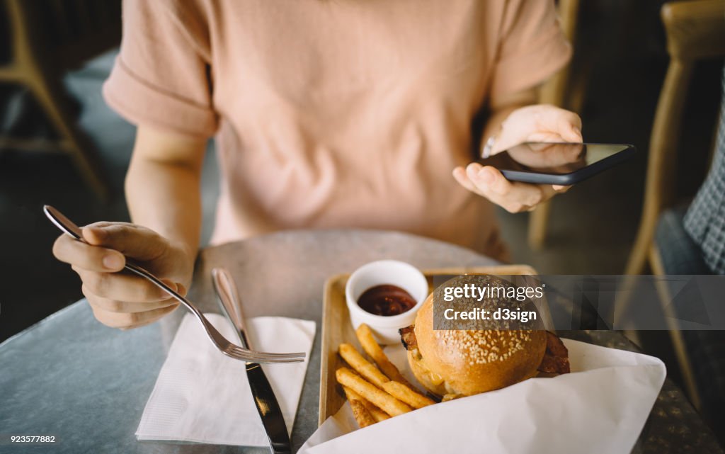 Woman Using Smartphone While Having Meal In A Restaurant High-Res Stock ...