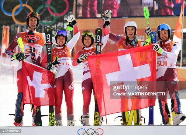 Switzerland's winners Ramon Zenhaeusern, Denise Feierabend, Wendy Holdener, Daniel Yule and Luca Aerni celebrate on the podium during the victory...