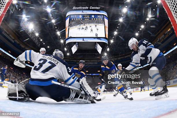 Connor Hellebuyck of the Winnipeg Jets and Bryan Little of the Winnipeg Jets defend against Vladimir Sobotka of the St. Louis Blues and Ivan...