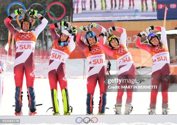 Switzerland's winners Ramon Zenhaeusern, Daniel Yule, Luca Aerni, Wendy Holdener and Denise Feierabend make heart shapes as they pose on the podium...
