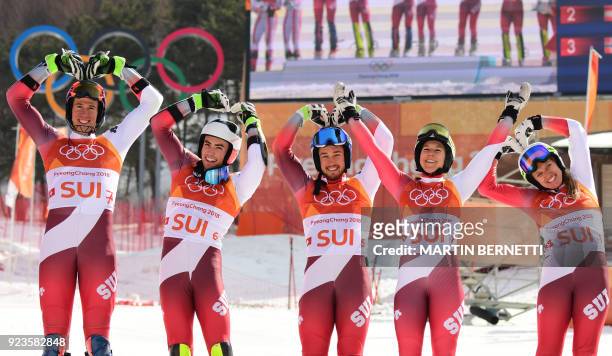 Switzerland's winners Ramon Zenhaeusern, Daniel Yule, Luca Aerni, Wendy Holdener and Denise Feierabend make heart shapes as they pose on the podium...