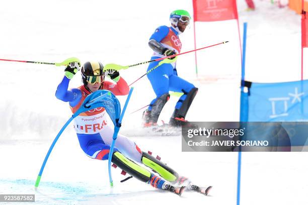 France's Clement Noel advances to the finish-line as Italy's Riccardo Tonetti stops competing in the Alpine Skiing Team Event quarter-finals at the...