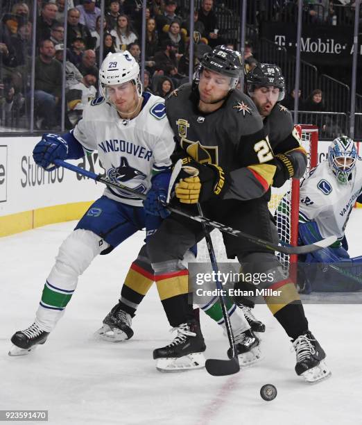 Philip Holm of the Vancouver Canucks and Stefan Matteau of the Vegas Golden Knights collide in front of Alex Tuch of the Golden Knights as they go...