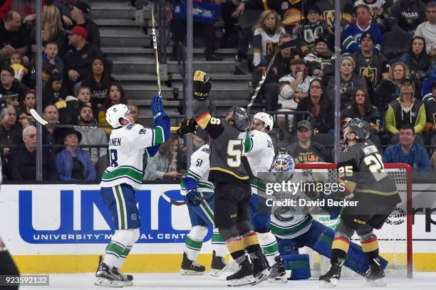 Erik Haula and Stefan Matteau of the Vegas Golden Knights battle for the puck after it is deflected into the air against Jake Virtanen, Michael Del...