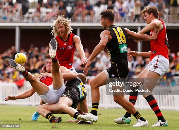 Joshua Begley of the Bombers is tackled by David Astbury of the Tigers during the JLT Community Series AFL match between the Essendon Bombers and the...