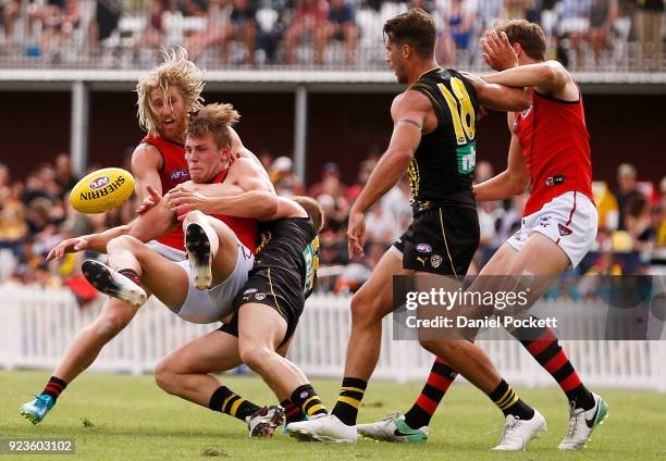 Joshua Begley of the Bombers is tackled by David Astbury of the Tigers during the JLT Community Series AFL match between the Essendon Bombers and the...