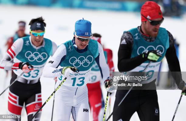 Max Hauke of Austria, Matti Heikkinen of Finland and Thomas Bing of Germany compete during the Men's 50km Mass Start Classic on day 15 of the...