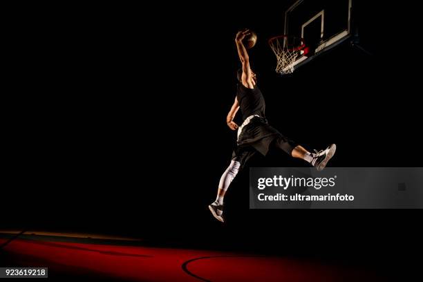 basketball player makes slam dunk - man dunking - slam dunk stock pictures, royalty-free photos & images