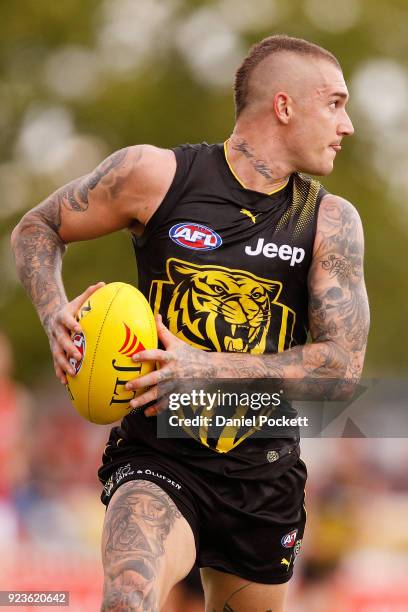 Dustin Martin of the Tigers runs with the ball during the JLT Community Series AFL match between the Essendon Bombers and the Richmond Tigers at Norm...