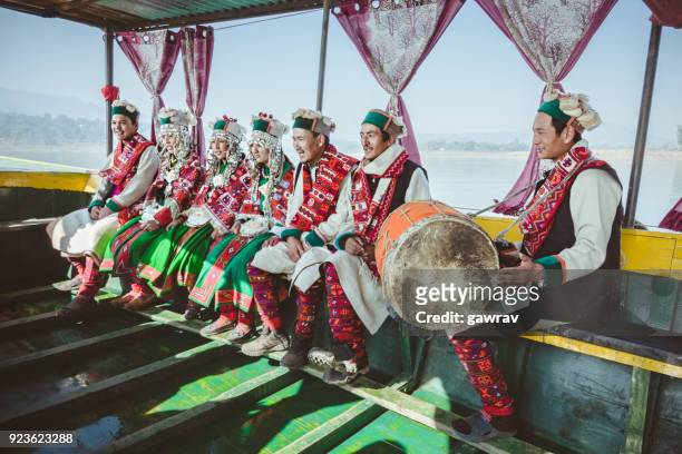 folk musician and dancers of kinnaur riding in a boat. - himachal pradesh stock pictures, royalty-free photos & images