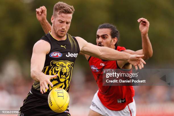 Kane Lambert of the Tigers kicks the ball under pressure from Jake Long of the Bombers during the JLT Community Series AFL match between the Essendon...