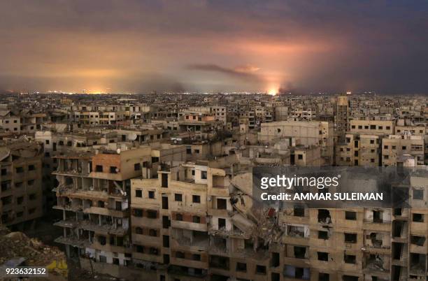 Smoke billows following a regime air strike on the besieged Eastern Ghouta region on the outskirts of the capital Damascus, late on February 23,...