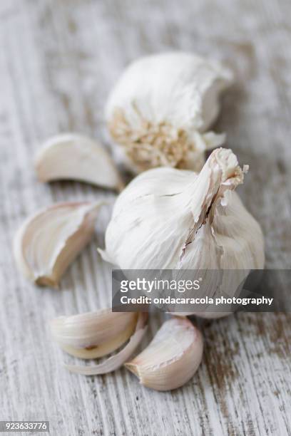 garlic cloves over a rustic background - aglio foto e immagini stock