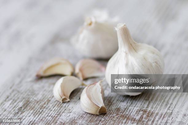 garlic cloves over a rustic background - garlic clove stock-fotos und bilder