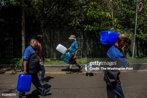 People refill water bottles at the Newlands spring tap, one of many fresh mountain spring that runs through the city on February 14, 2018. Citizens...