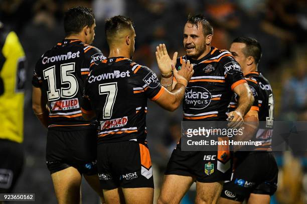 Josh Reynolds of the Tigers celebrates with team mates after Corey Thompson of the Tigers scores a try during the NRL trial match between the...