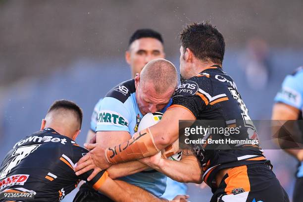 Luke Lewis of the Sharks is tackled during the NRL trial match between the Cronulla Sharks and the Wests Tigers at Campbelltown Sports Stadium on...